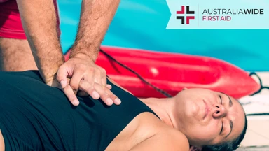 A man giving CPR to an unconscious female swimmer